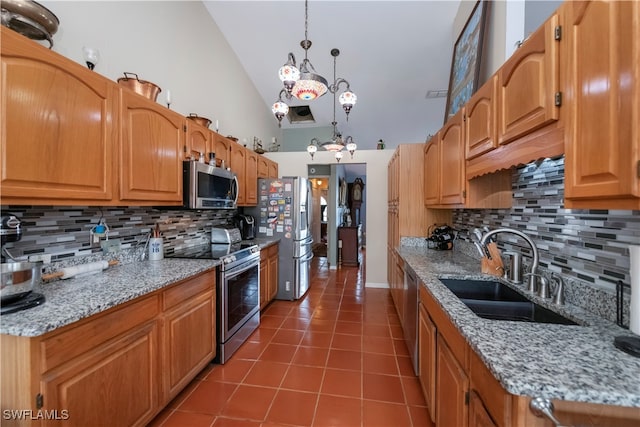 kitchen featuring decorative backsplash, hanging light fixtures, light stone countertops, sink, and stainless steel appliances