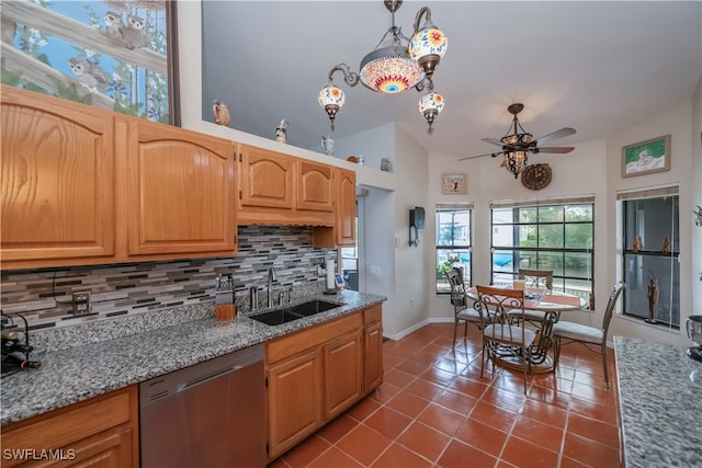 kitchen with tasteful backsplash, stainless steel dishwasher, hanging light fixtures, and sink