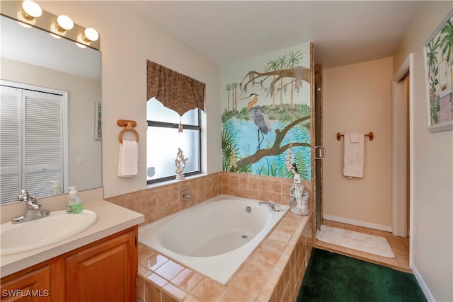 bathroom featuring vanity, tiled bath, and tile patterned flooring