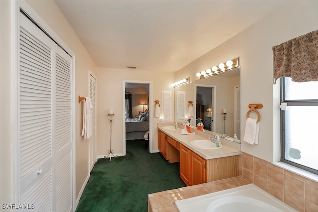 bathroom with vanity and a relaxing tiled tub