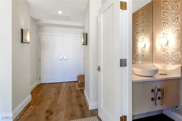 hallway featuring sink and hardwood / wood-style floors