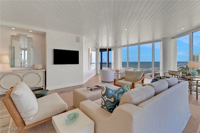 living room with light hardwood / wood-style floors, a wall of windows, wooden ceiling, and plenty of natural light