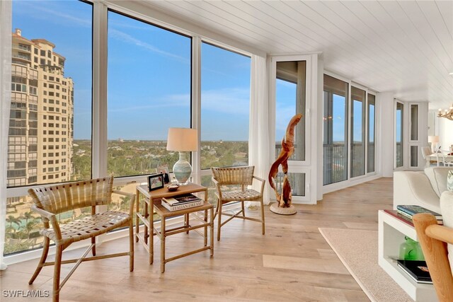 sunroom with a notable chandelier and wooden ceiling