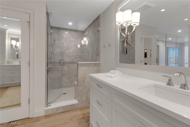 bathroom featuring a shower with door, vanity, and wood-type flooring