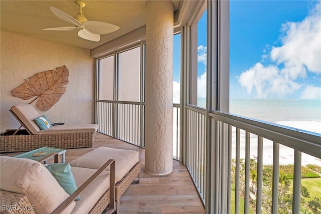 sunroom with a water view and ceiling fan