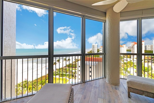 sunroom / solarium featuring a water view and a view of the beach