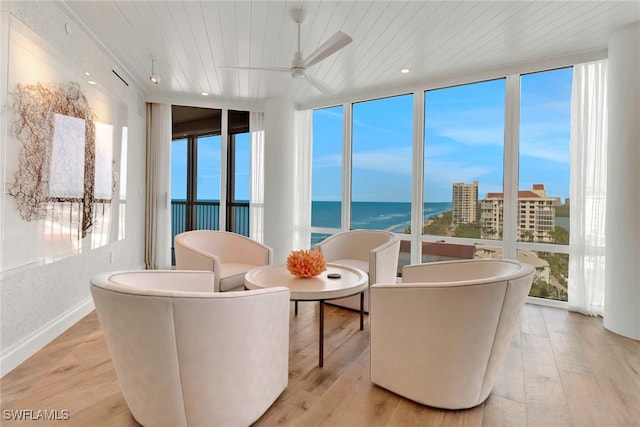 sunroom featuring wood ceiling, a water view, and ceiling fan