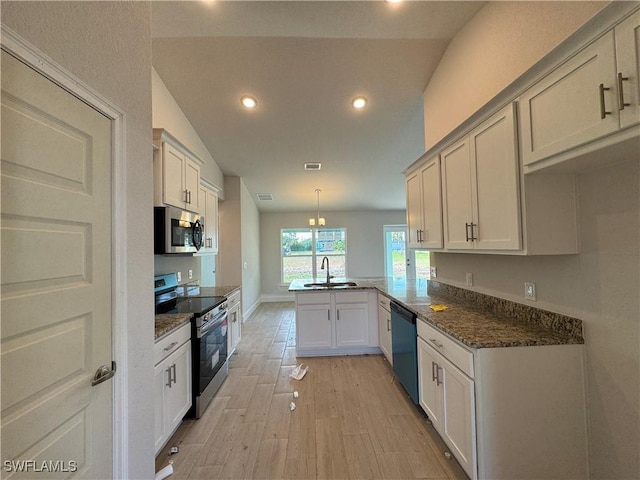 2112 NW 22nd Ave, Cape Coral, FL 33993 - kitchen featuring appliances with stainless steel finishes, a sink, a peninsula, light wood-type flooring, and recessed lighting