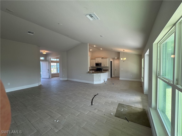 unfurnished living room with a textured ceiling and lofted ceiling