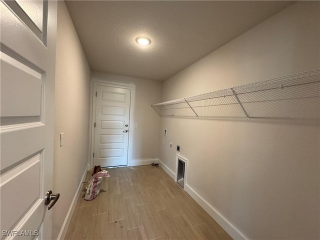 2112 NW 22nd Ave, Cape Coral, FL 33993 - laundry area with electric dryer hookup, baseboards, light wood finished floors, and a textured ceiling