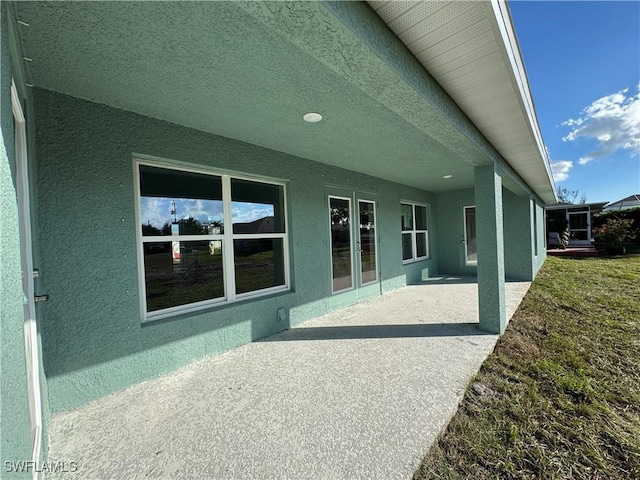 2112 NW 22nd Ave, Cape Coral, FL 33993 - rear view of property featuring stucco siding and a patio