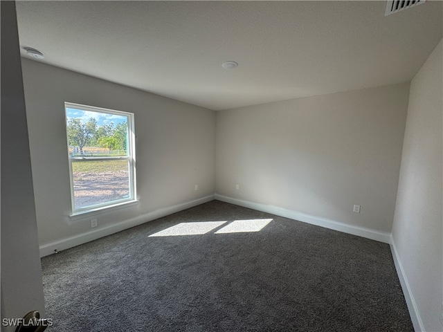 empty room featuring dark colored carpet