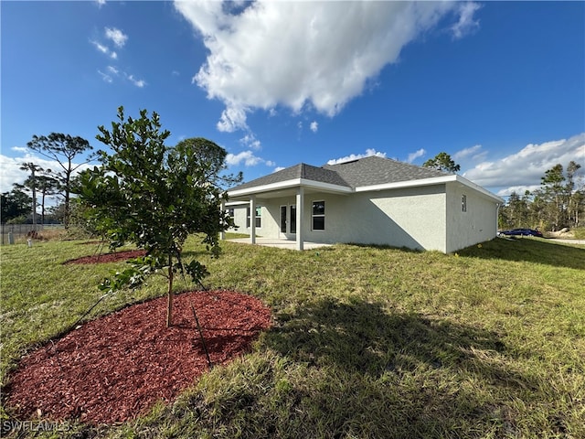 rear view of house featuring a lawn and a patio