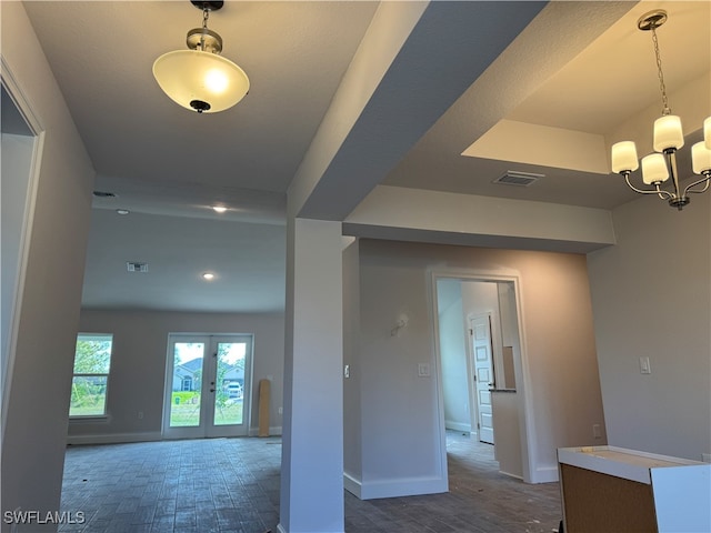 interior space with dark hardwood / wood-style flooring, french doors, and an inviting chandelier