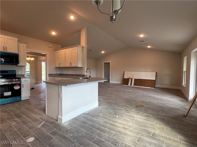 kitchen with dark stone counters, vaulted ceiling, dark wood-type flooring, electric range, and white cabinets