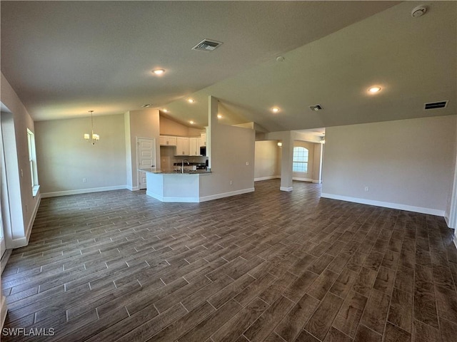 2324 Jacaranda Pkwy W, Cape Coral, FL 33993 - unfurnished living room featuring visible vents, dark wood-style flooring, lofted ceiling, baseboards, and a sink