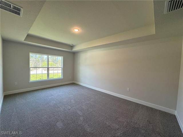 2324 Jacaranda Pkwy W, Cape Coral, FL 33993 - empty room with baseboards, visible vents, a raised ceiling, and dark colored carpet