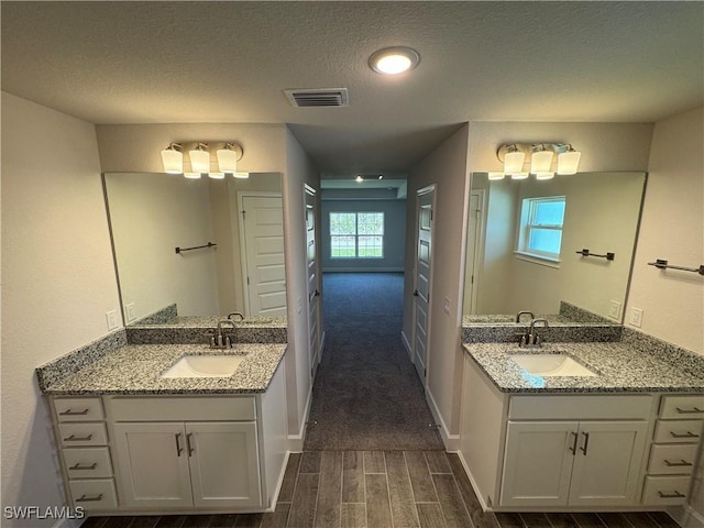 2324 Jacaranda Pkwy W, Cape Coral, FL 33993 - bathroom featuring visible vents, a sink, wood finished floors, and two vanities