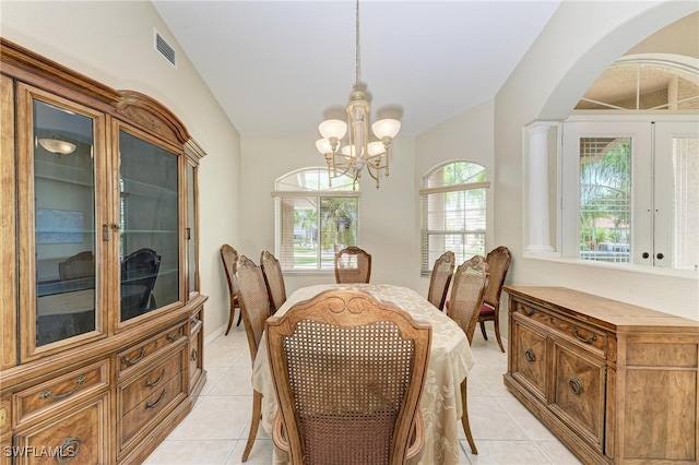 dining area with an inviting chandelier, vaulted ceiling, light tile patterned flooring, ornate columns, and french doors