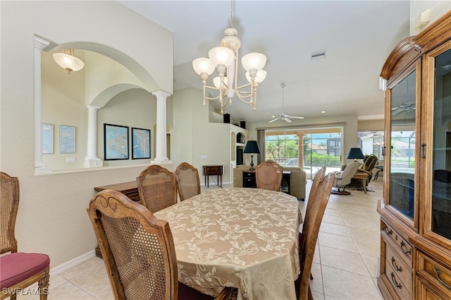 tiled dining room with ornate columns and ceiling fan with notable chandelier