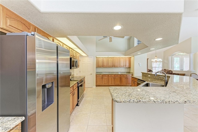 kitchen with ceiling fan, a textured ceiling, appliances with stainless steel finishes, and sink