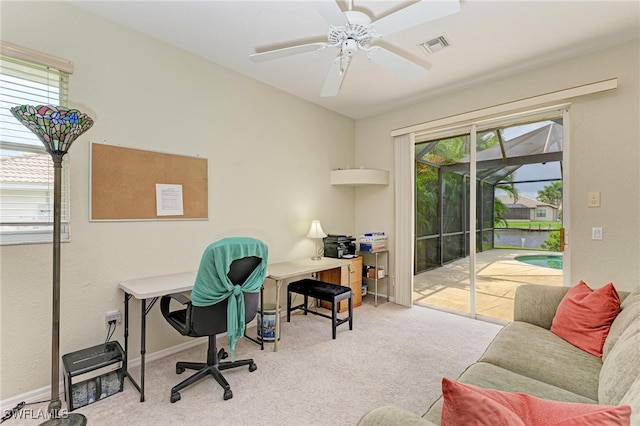 home office featuring light carpet and ceiling fan