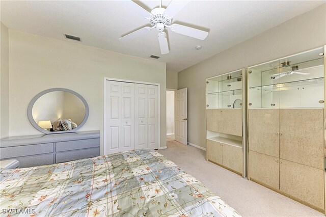 unfurnished bedroom featuring light colored carpet, a closet, and ceiling fan