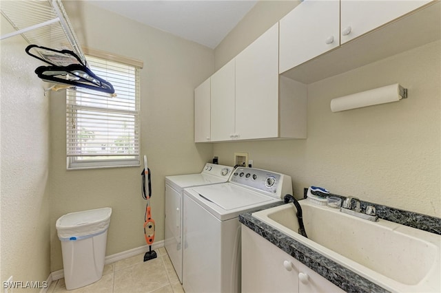 laundry area featuring sink, light tile patterned floors, cabinets, and washing machine and clothes dryer