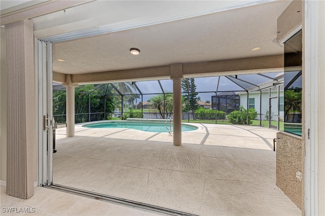 view of pool with a patio and glass enclosure