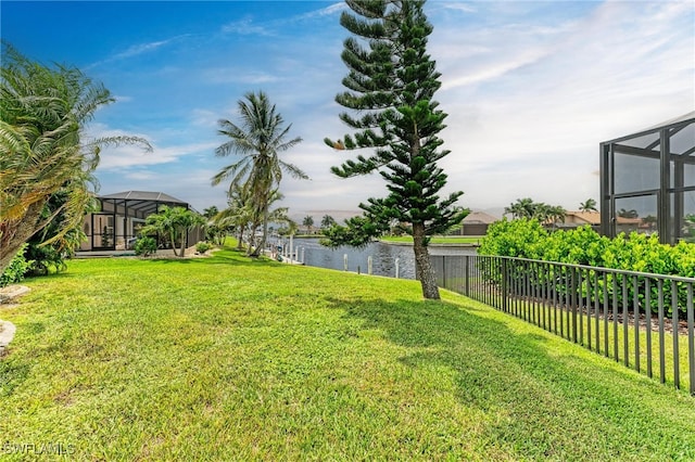 view of yard with a water view and a lanai