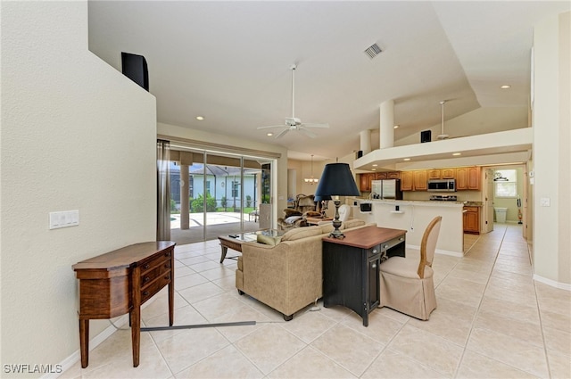 living room featuring vaulted ceiling, light tile patterned floors, and ceiling fan