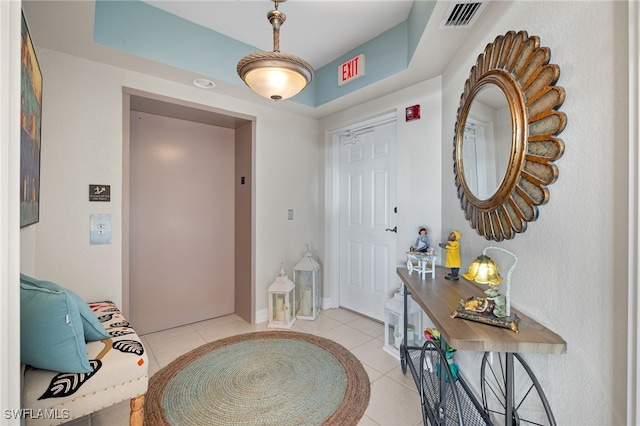 foyer entrance featuring elevator and light tile patterned floors