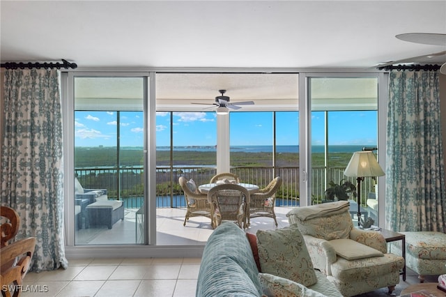 sunroom / solarium featuring a water view and ceiling fan