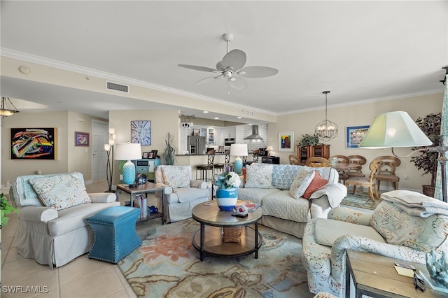 tiled living room with crown molding and ceiling fan with notable chandelier