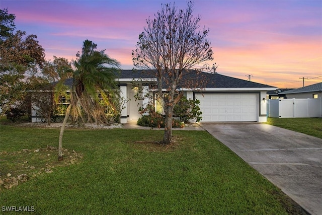 view of front of property with a garage and a lawn