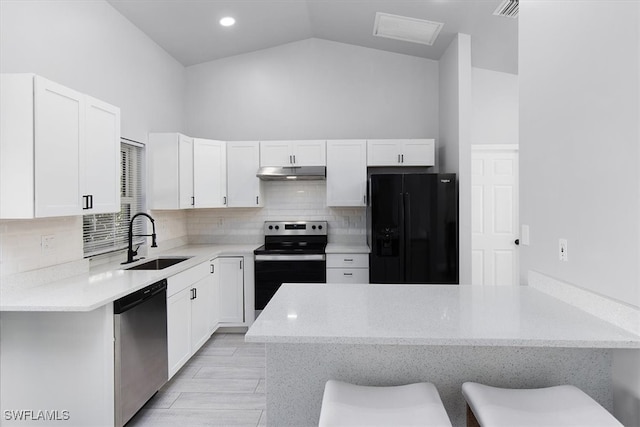 kitchen featuring sink, stainless steel appliances, white cabinetry, and a breakfast bar