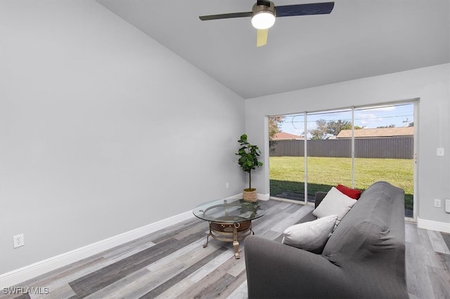 living room featuring lofted ceiling, light hardwood / wood-style flooring, and ceiling fan