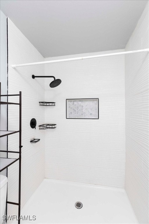 bathroom featuring toilet and a tile shower