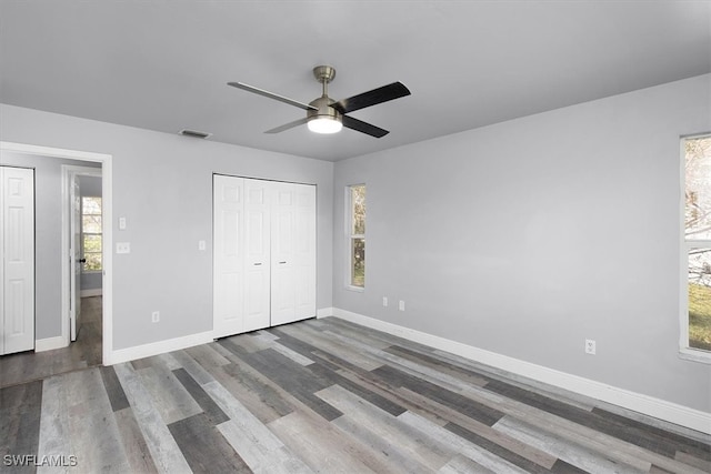 unfurnished bedroom featuring a closet, hardwood / wood-style floors, and ceiling fan