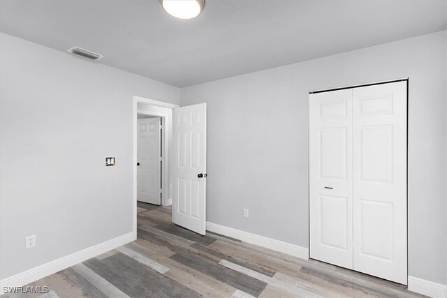 unfurnished bedroom featuring a closet and wood-type flooring