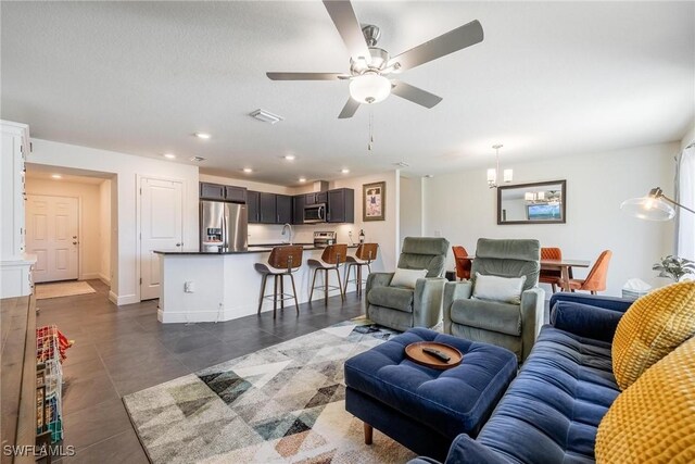 15050 Caspian Tern Ct Unit 102, North Fort Myers, FL 33917 - living room featuring dark tile patterned floors, ceiling fan with notable chandelier, visible vents, baseboards, and recessed lighting