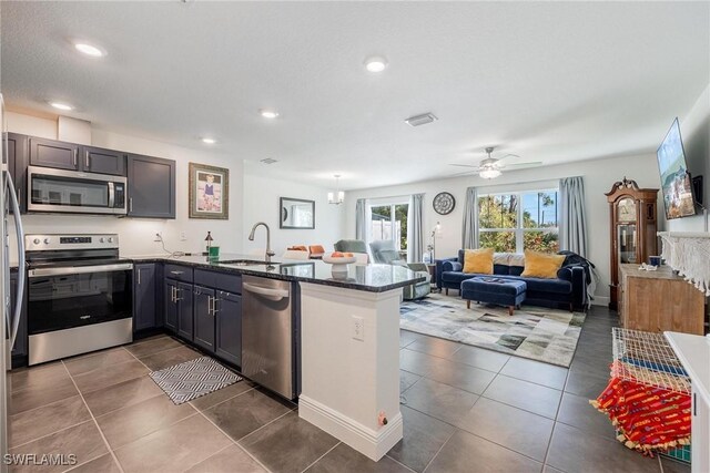 15050 Caspian Tern Ct Unit 102, North Fort Myers, FL 33917 - kitchen with a sink, a peninsula, open floor plan, dark tile patterned flooring, and appliances with stainless steel finishes