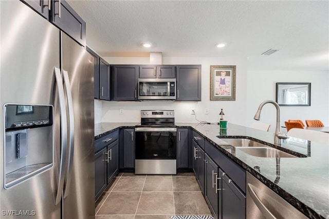 15050 Caspian Tern Ct Unit 102, North Fort Myers, FL 33917 - kitchen featuring a sink, dark stone counters, appliances with stainless steel finishes, light tile patterned flooring, and recessed lighting