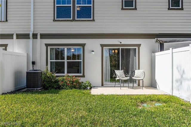 15050 Caspian Tern Ct Unit 102, North Fort Myers, FL 33917 - back of property with a patio, stucco siding, fence, a lawn, and central air condition unit