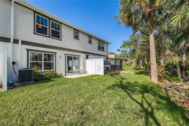 15050 Caspian Tern Ct Unit 102, North Fort Myers, FL 33917 - rear view of house with stucco siding, central AC, and a lawn
