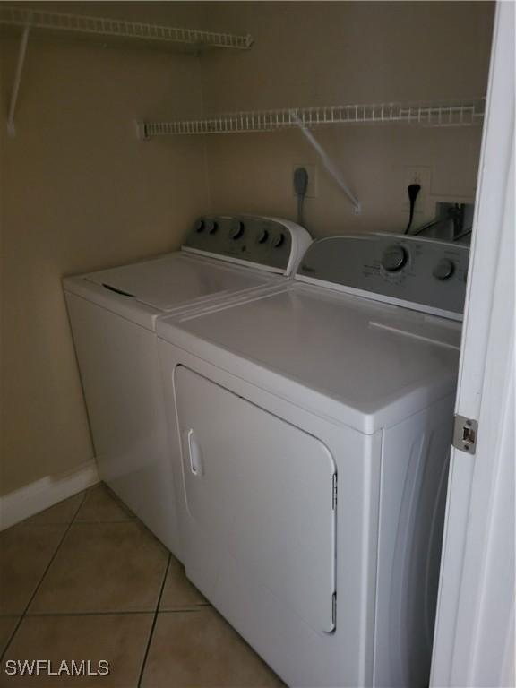 laundry room featuring washer and dryer and light tile patterned floors