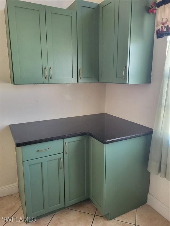 kitchen featuring light tile patterned floors and green cabinetry