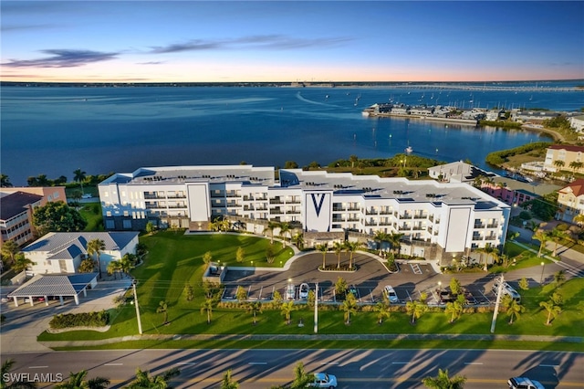 aerial view at dusk featuring a water view