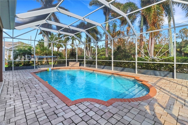 view of swimming pool featuring a patio and glass enclosure