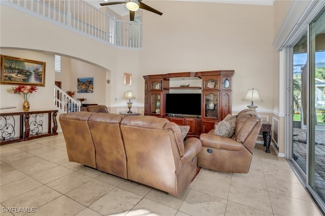 tiled living room featuring ceiling fan and a towering ceiling